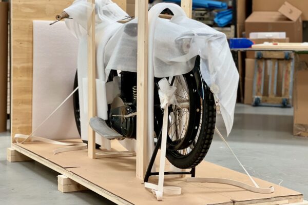 Motorcycle wrapped in thin foam with support boards and secured with cotton straps