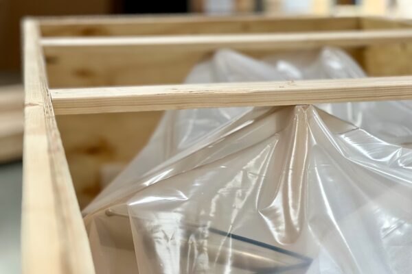 Clear plastic covering contents in open wooden crate